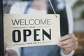 Close up of womanÃâ¬Ãâ¢ hands holding sign now we are open support local business Royalty Free Stock Photo